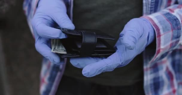 男性手戴手套，打开钱包，在大流行病期间只拿出两块钱，最后一块钱 — 图库视频影像