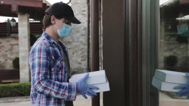 Kurýr v masce klepe na vstupní dveře domu převést objednávku na klienta — Stock video