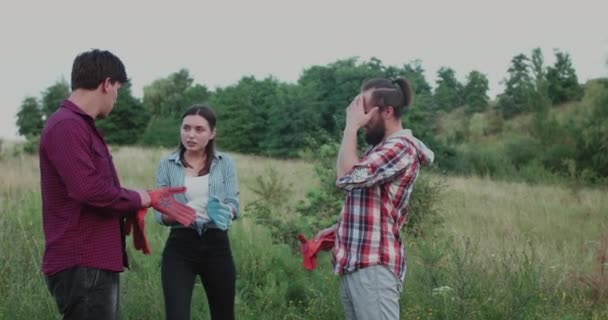 Jóvenes hablando emocionalmente, usando guantes y sonriendo a la naturaleza — Vídeos de Stock