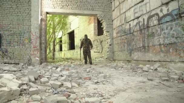 Blick auf Kämpfer in Tarnform, die Fackeln an Ruinen wedeln lassen — Stockvideo
