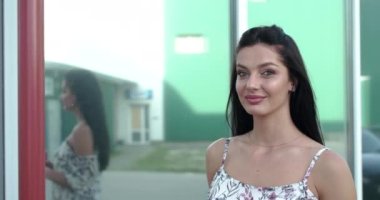 Neşeli bayan bir bardak içki içer ve ofis merkezinde gülümser.