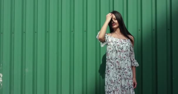 Pretty brunette in light dress pose dengan rambut di latar belakang selama angin — Stok Video