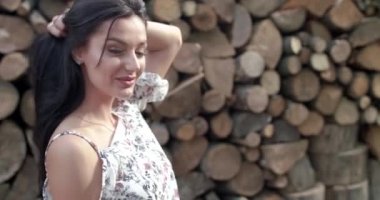 Üfleme elbiseli güzel esmer saçlarıyla poz veriyor ve tahtaya gülümsüyor.