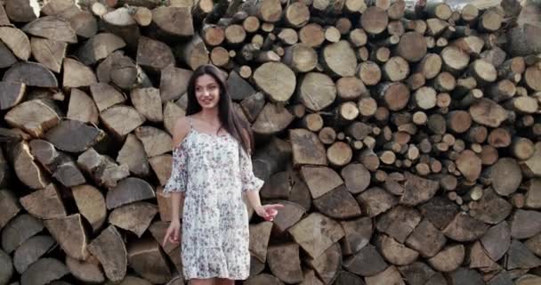 優雅な女性で柔らかいドレス旋回と笑顔でカメラで木の背景 — ストック動画