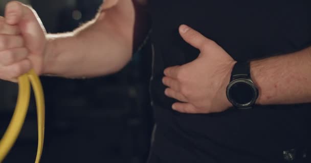 Man hand dra loop för armmusklerna i ett mörkt gym — Stockvideo