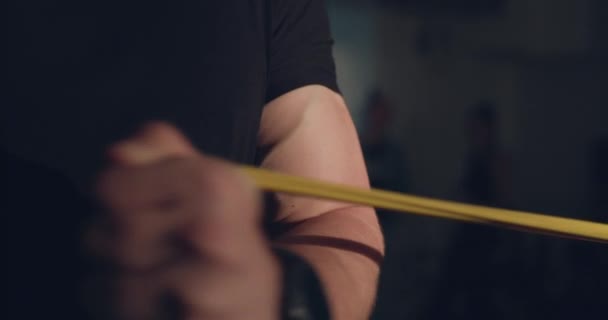 暗いジムで手でループを引っ張っ中に静脈と男性膨脹腕のビュー — ストック動画
