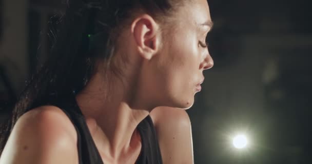 Portrait d'athlète féminine avec queue de cheval à cheveux attachés regarde sérieusement de côté dans la salle de gym — Video