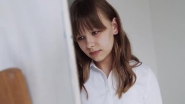 Easel 'de çocuk resimleri, atölye sınıfında okul çocuğu. Sınıfta Sanat Sanatında Çalışan Genç Kız