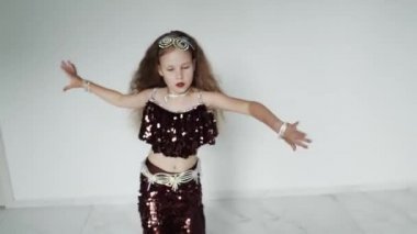 Kız kırmızı elbiseli bir kamerada dans ediyor.