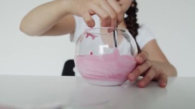 Kız elleri balçığı birbirine karıştırıyor.