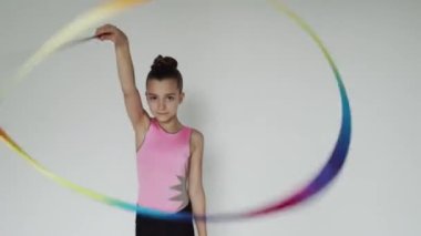 Genç kız renkli kurdeleyle hamle yapıyor.