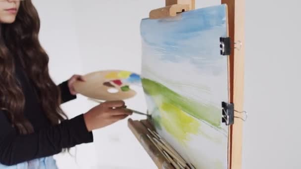 Sanat stüdyosunda resim yapan genç bir kadın sanatçı. — Stok video