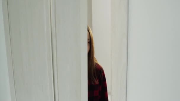 Teenage girl opens light doors and enters the room — Stockvideo