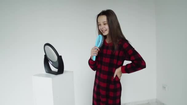 Singing girl using her hairbrush insted of the microphone — Stockvideo