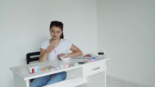 Girl edds beads step by step, young lady at the table — Stock videók