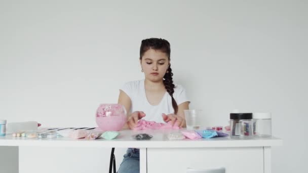 Gadis itu mencampur lendir elastis di atas meja — Stok Video