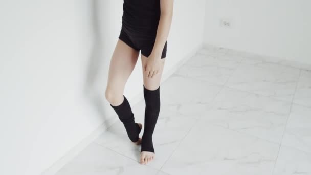 Hidas liike nainen, joka nostaa jalkansa päähän — kuvapankkivideo