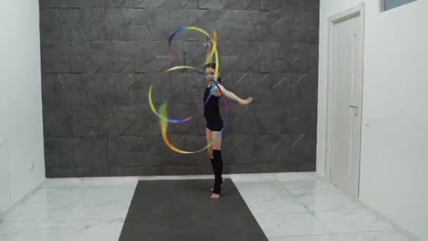 Smiling school girl makes moves with ribbon in a studio — Wideo stockowe