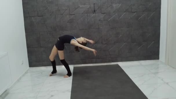 Girl slowly does the cartwheels on black background — ストック動画