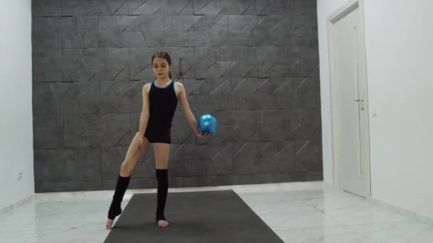 Приваблива дівчина робить ритмічні ходи з м'ячем — стокове відео