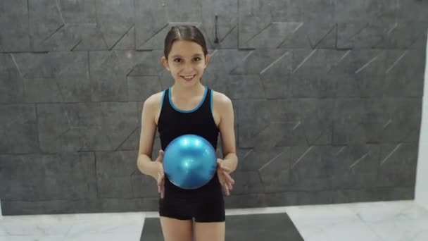 Biała dziewczyna uśmiechnięta i chodząca z piłką — Wideo stockowe