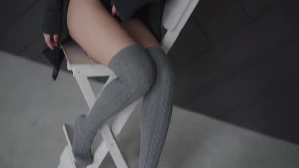 View of seductive brunette in black lingerie poses on chair in studio — Vídeo de Stock