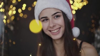 İçerideki kameraya gülümseyen kırmızı şapkalı çekici kızın portresi.