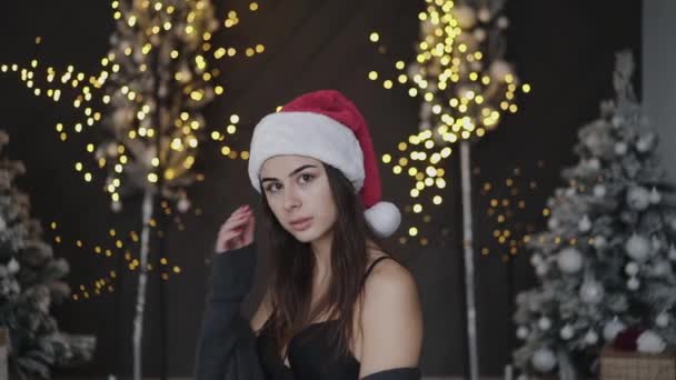 Spójrz na aparat enigmatycznej brunetki w erotycznym stylu noworocznym pozuje w studio — Wideo stockowe