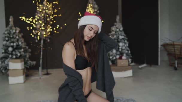 Erotic santa girl poses in lingerie at camera in decorated studio — Vídeo de Stock