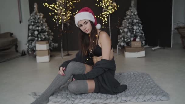 Hot brunette in new years hat and lingerie thoughtfully poses at camera — Video Stock