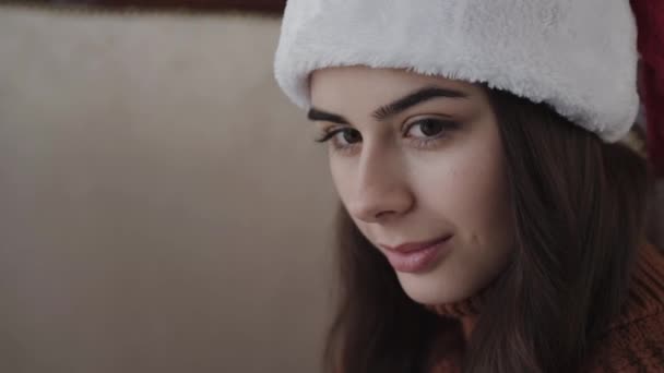 Close portret pięknej uśmiechniętej dziewczyny w kapeluszu noworocznym — Wideo stockowe