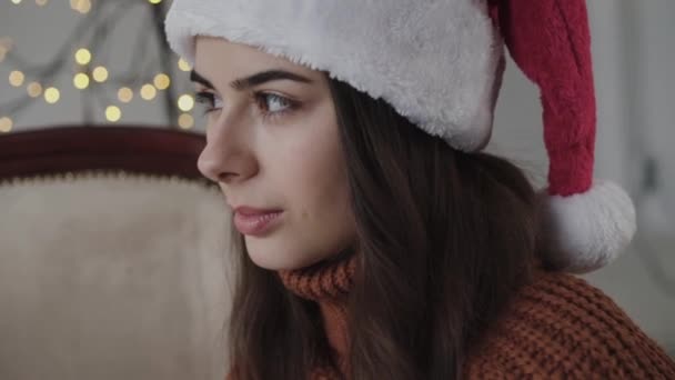 Close portrait of beautiful girl in new year hat with light smile — Video Stock