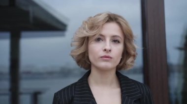 Dışarıdaki kameraya bakıp gülümseyen güzel bir kızın portresi.