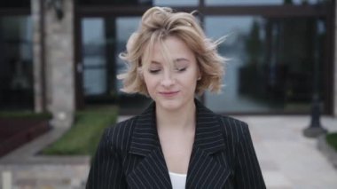 Gülümseyen kızın portresi kameraya gözlerini açar ve ellerini çaprazlar.