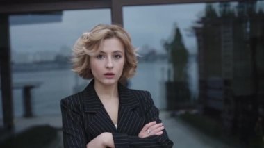 Dışarıda el ele tutuşan ciddi bir kadının portresi.