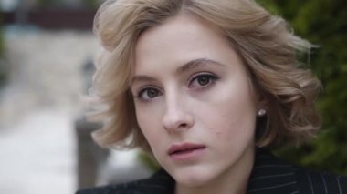 Güzel sarışının yakın portresi dışarıdaki kameraya bakıyor.