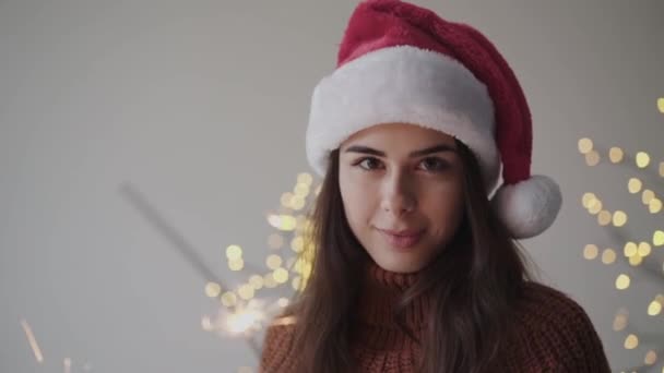 Portré boldog lány újévi kalap tartja égő csillagszórók és mosoly — Stock videók