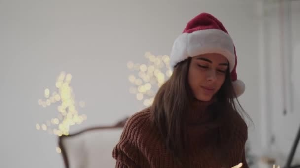 Boldog lány újévi kalap játszik égő csillagszórók és megmutatja nekik a kamera — Stock videók