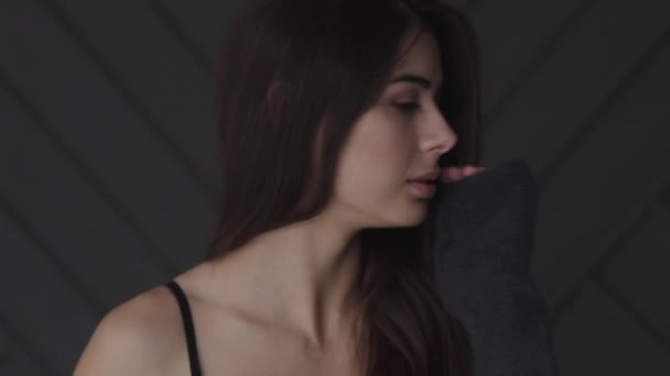 Morena em lingerie preta toca seu rosto e olha para a câmera no estúdio — Vídeo de Stock