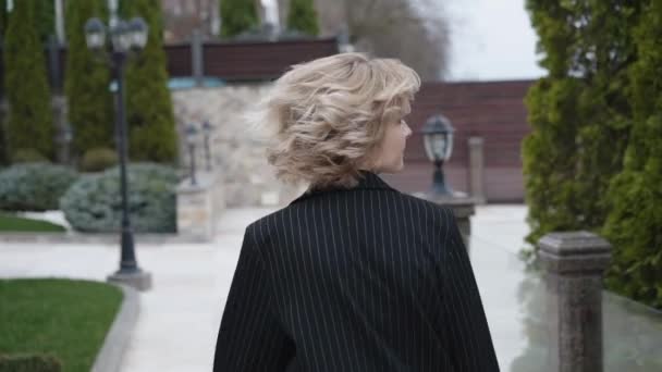 Stylová blondýnka kráčí, pózuje a otáčí se na foťáku ourdoors — Stock video