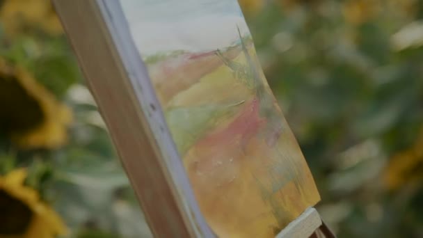 Close view of applying a watercolour on canvas with landscape with brush