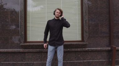 Bir erkek kulaklıkla müzik dinlemekten hoşlanır.