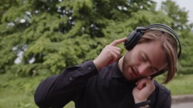 Bir adam müzik dinler ve dans eder.