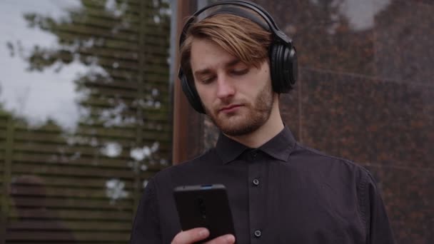 Um homem feliz em fones de ouvido recebeu uma mensagem — Vídeo de Stock