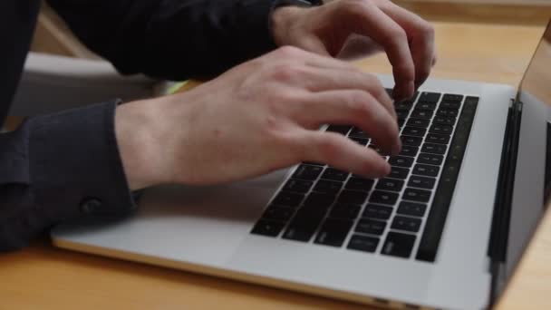 Hombre escribiendo en un nuevo ordenador portátil moderno — Vídeos de Stock