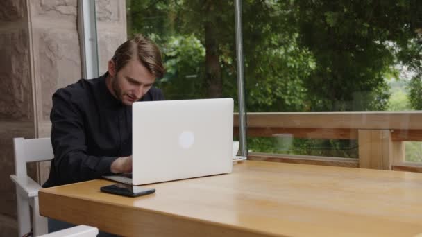 Szczęśliwy i uśmiechnięty facet zamknął laptopa po pracy — Wideo stockowe