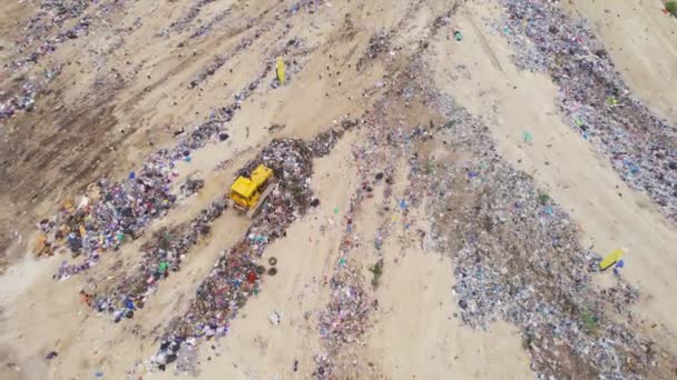 Çöp yığını. Çöplükte buldozer var. Çöpü ve çöpü hareket ettiren buldozerin hava görüntüsü. — Stok video