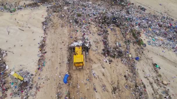 Basura de basura. Bulldozer en el vertedero de basura. Tiro aéreo de la topadora moviendo la basura y la basura — Vídeo de stock