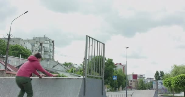 Паркур атлет делает экстремальные передние флип с выступа на городской скейтборд трек — стоковое видео