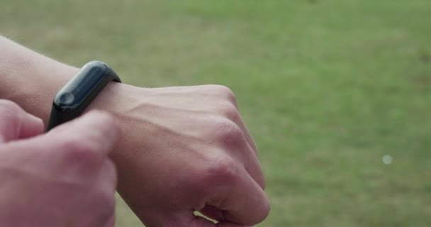 Vedere atentă a utilizării brățării inteligente pe mâna masculină în aer liber — Videoclip de stoc